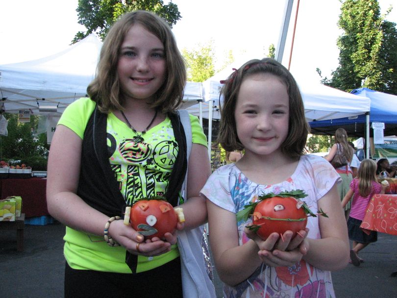 Amber Andersen, 12 (left) and Amia Delaney, 7, hold up their creative entries in the tomato beauty pageant at the South Perry Farmers' Market's tomato festival on Aug. 19, 2010. (Pia Hallenberg)