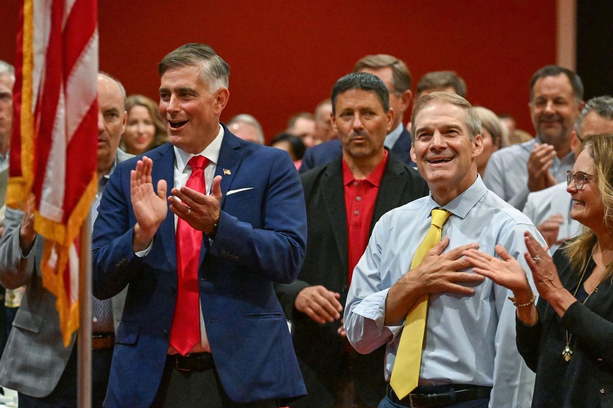 U.S. Rep. Michael Baumgartner, of Spokane, left, and U.S. Rep. Jim Jordan, of Ohio, applaud national anthem singer Vella Paulson on Sunday during the Paint It Red event at the Davenport Grand Hotel in Spokane. (DAN PELLE/FOR THE SPOKESMAN-REVIEW)