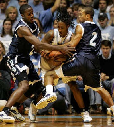 
North Carolina's Quentin Thomas, center, is pressured by North Carolina-Wilmington's Taylor Lay, left and T.J. Carter.
 (Associated Press / The Spokesman-Review)