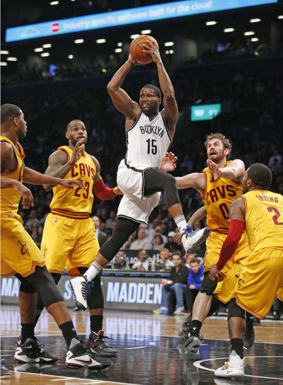 Nets’ guard Donald Sloan looks to pass as Cavs’ forwards LeBron James and Kevin Love defend, in the Nets’ Thursday night win. (Kathy Willens / Associated Press)