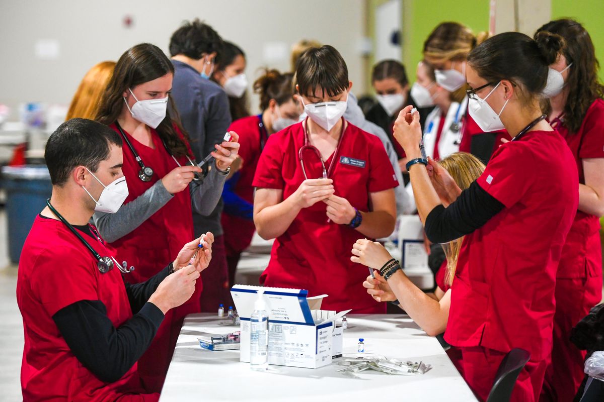 WSU College of Veterinary Medicine students prepare canine vaccines during the Heathy People + Healthy Pets free health care service clinic for homeless and low-income people and their pets Wednesday at 412 E. Spokane Falls Blvd. in Spokane.  (Dan Pelle/THE SPOKESMAN-REVIEW)