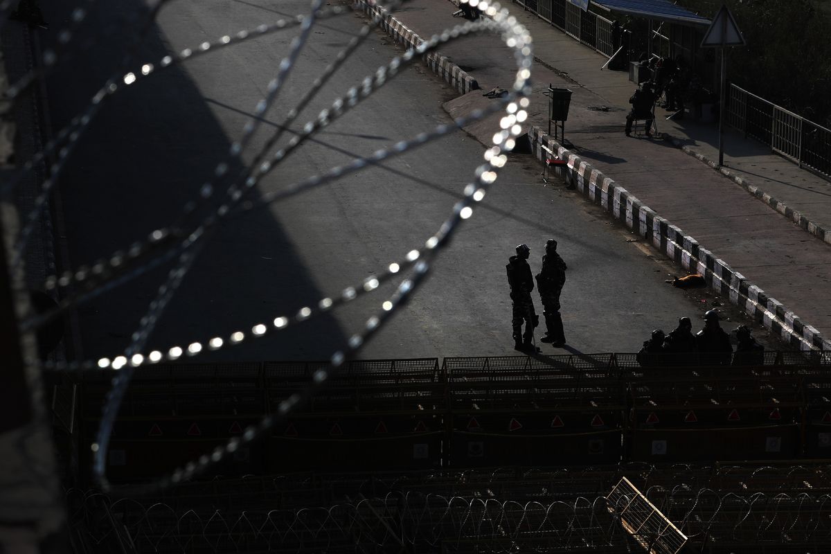 Indian paramilitary force soldiers stand guard at a heavily barricaded road along one of the three main protest sites outside New Delhi’s border to thwart the growing farmers’ protest on the edges of the capital Friday.  (Manish Swarup)