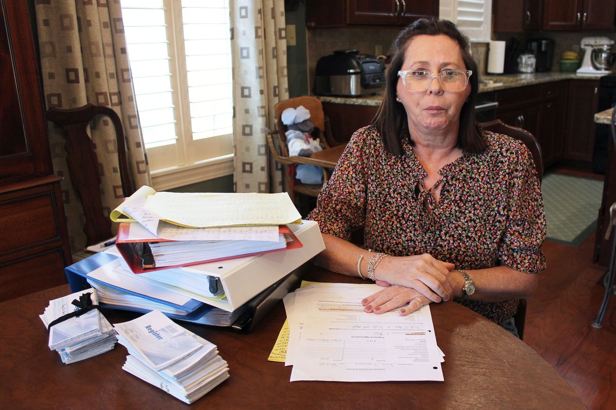 Jonna Tallant, a longtime TMJ patient, displays a pile of medical records and billing documents at her home in Knoxville, Tennessee. She has spent a small fortune on TMJ treatment over three decades, but remains in agony and is unable to eat solid food.  (KFF Health News)