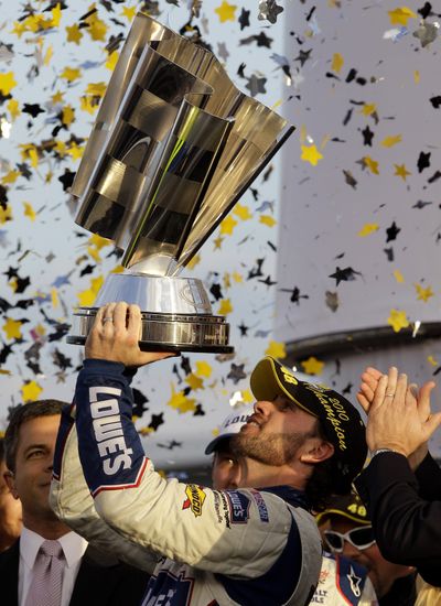 Jimmie Johnson holds up the Sprint Cup trophy for the fifth straight year. (Associated Press)