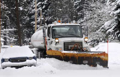 
City of Spokane employee Jim Biggar clears the roadway of snow near the corner of Everett and Bemis on Wednesday. 
 (Dan Pelle / The Spokesman-Review)