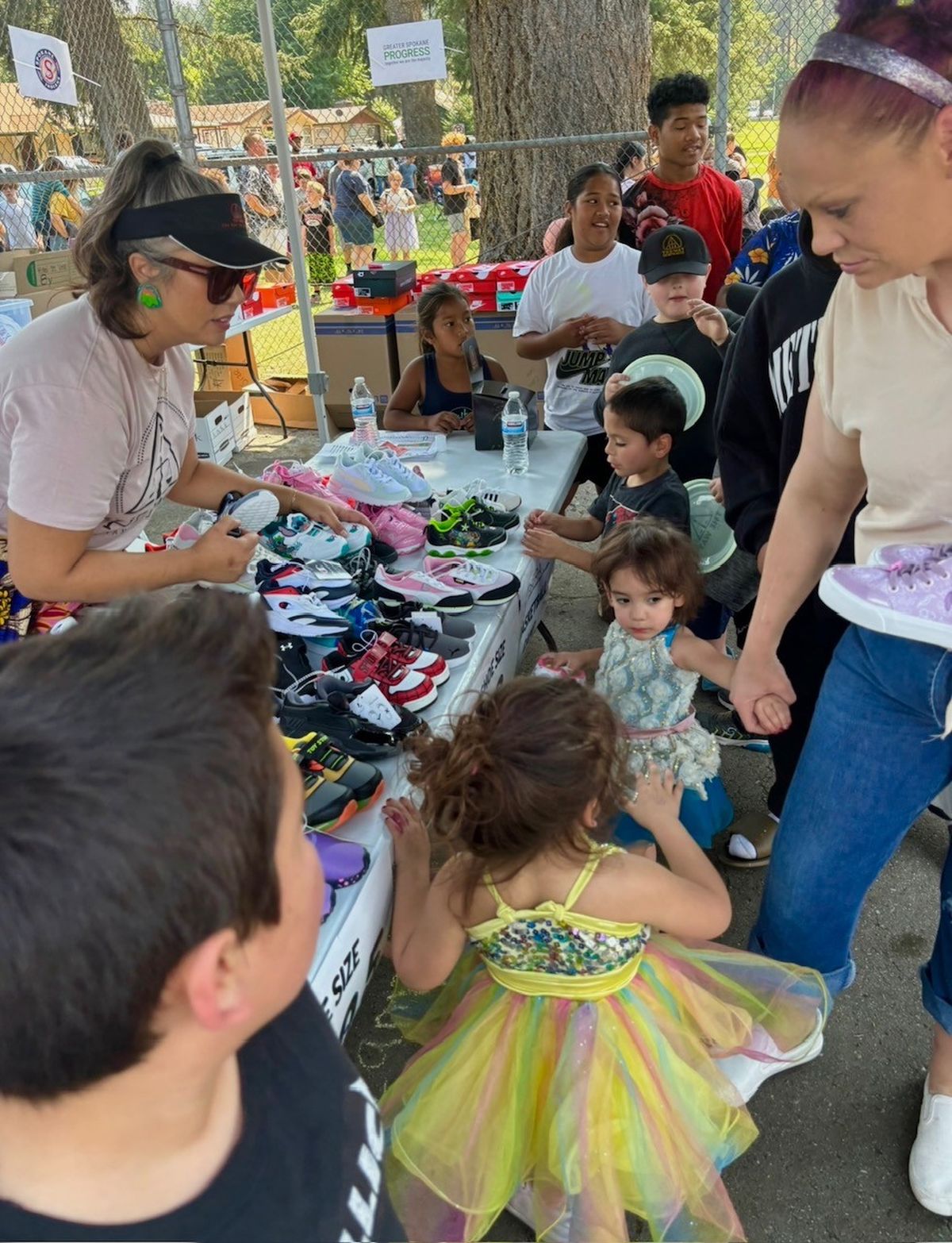 Families roam the booths looking for the right size of shoes at a SERA event August 10, 2024.   (Z