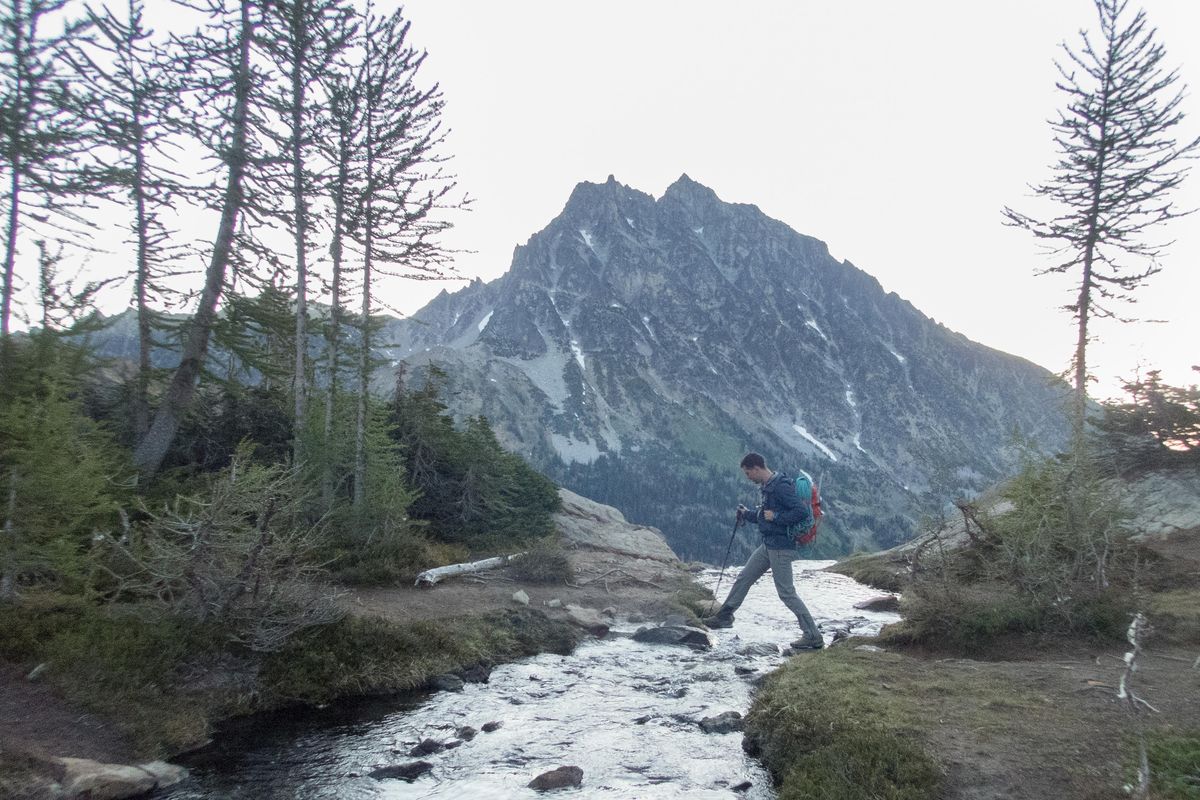 Will Holmquist crosses a stream on July 5 near Lake Ingalls in the Cascades. Mt. Stuart is visible in the background. (Eli Francovich/THE SPOKESMAN-REV / SR)