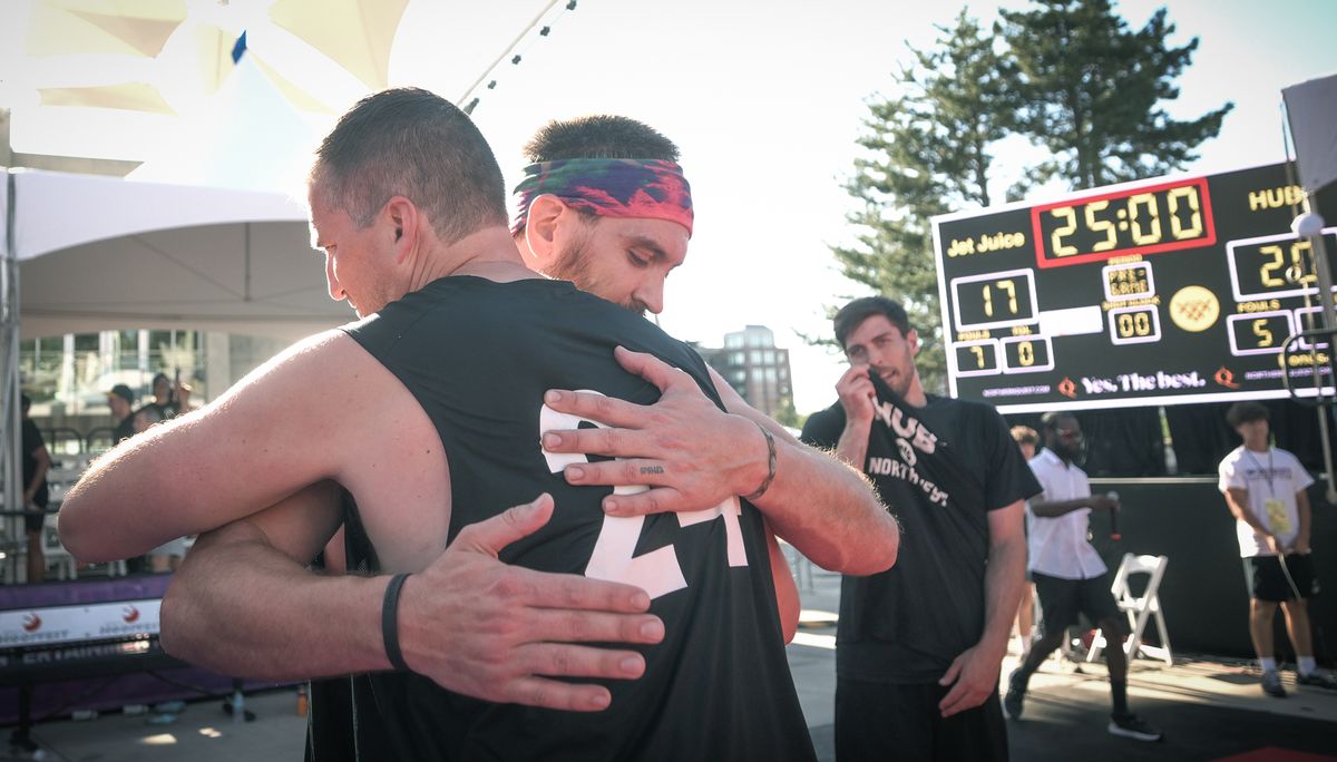 Hub Northwest’s Marc Axton, left, is embraced by a teammate after their men’s elite 6-foot-and-over championship Sunday at Hoopfest. (Brian Plonka/For The Spokesman-Review)
