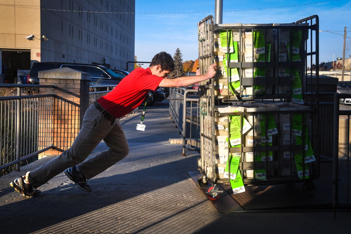 Ryan Dosch, voter services specialist at the Spokane County Elections Office, rolls a cart weighting 840 pounds with ballots into a Penske truck headed to the post office, Thursday, Oct. 18, 2018. The Elections Office is mailing out more than 310,000 ballots for the general election. (Dan Pelle / The Spokesman-Review)