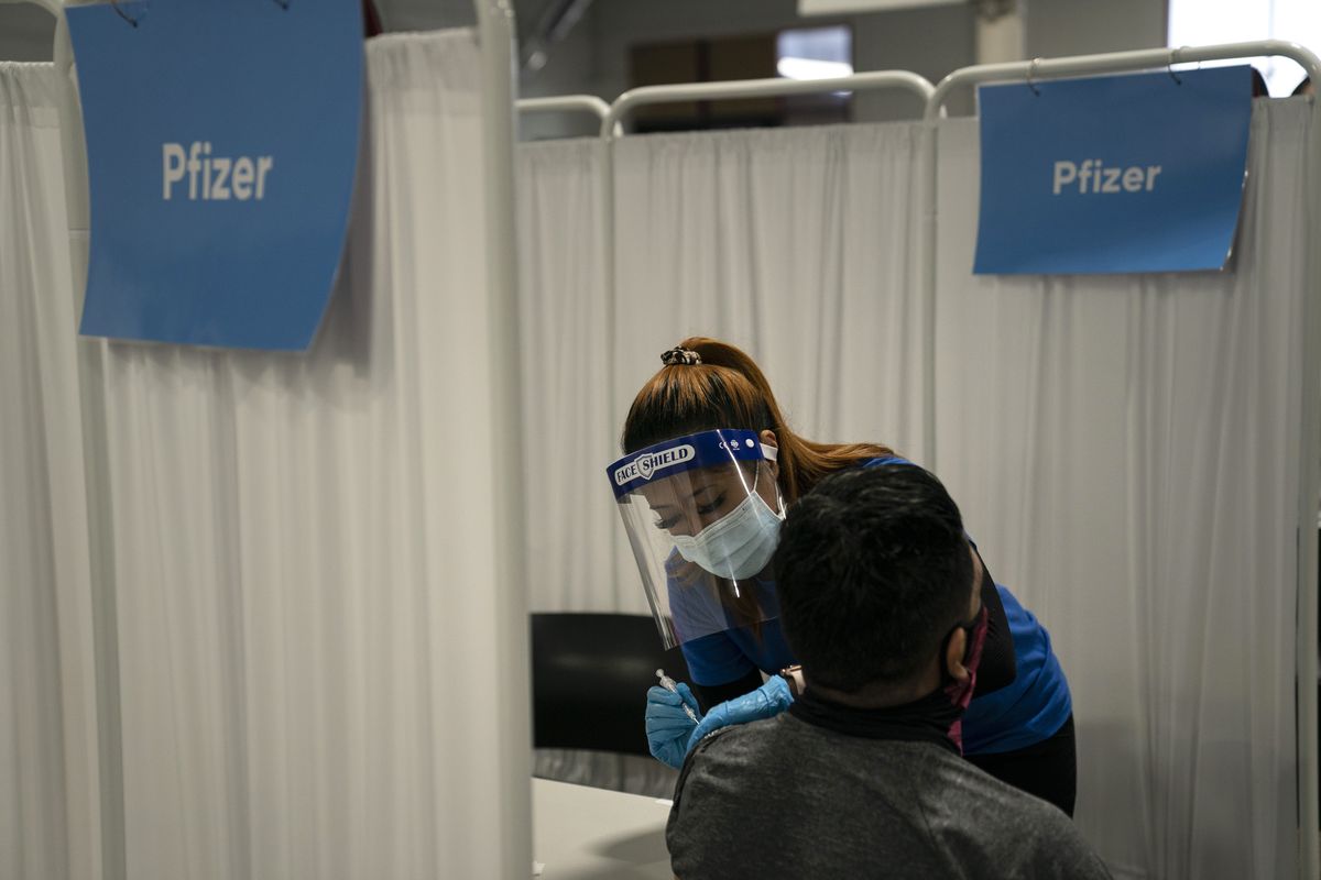 FILE - In this May 21, 2021, file photo, licensed vocational nurse Angeline Gabuten administers the Pfizer COVID-19 vaccine to a patient at Providence Edwards Lifesciences vaccination site in Santa Ana, Calif. With booster doses of Pfizer’s COVID-19 vaccine now authorized in the U.S., government advisers reconvened on Thursday, Sept. 23, to tackle the most contentious question yet: Exactly who should roll up their sleeves right away?  (Jae C. Hong)