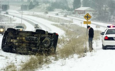 Chase Porter waits for a tow truck to arrive after he rolled his Mazda truck on Highway 195 just north of Inland Empire Way on Monday. Porter was on his way to Spokane Falls Community College for morning classes.
 (Kathryn Stevens / The Spokesman-Review)