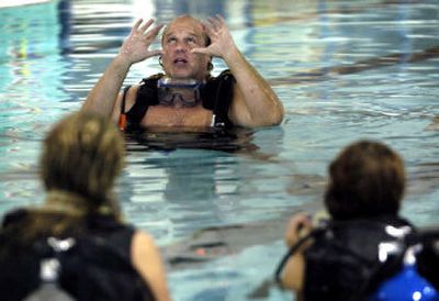 
Scuba Center of Spokane owner Jamie Mankin shows participants in a scuba certification class how to clear the face mask while underwater in a YWCA pool Thursday. 
 (The Spokesman-Review)