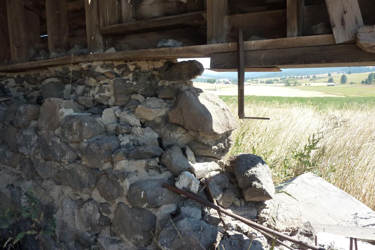 The foundation as photographed from inside the barn’s first level shows daylight through a hole in the crumbling rock foundation. (Stefanie Pettit / The Spokesman-Review)
