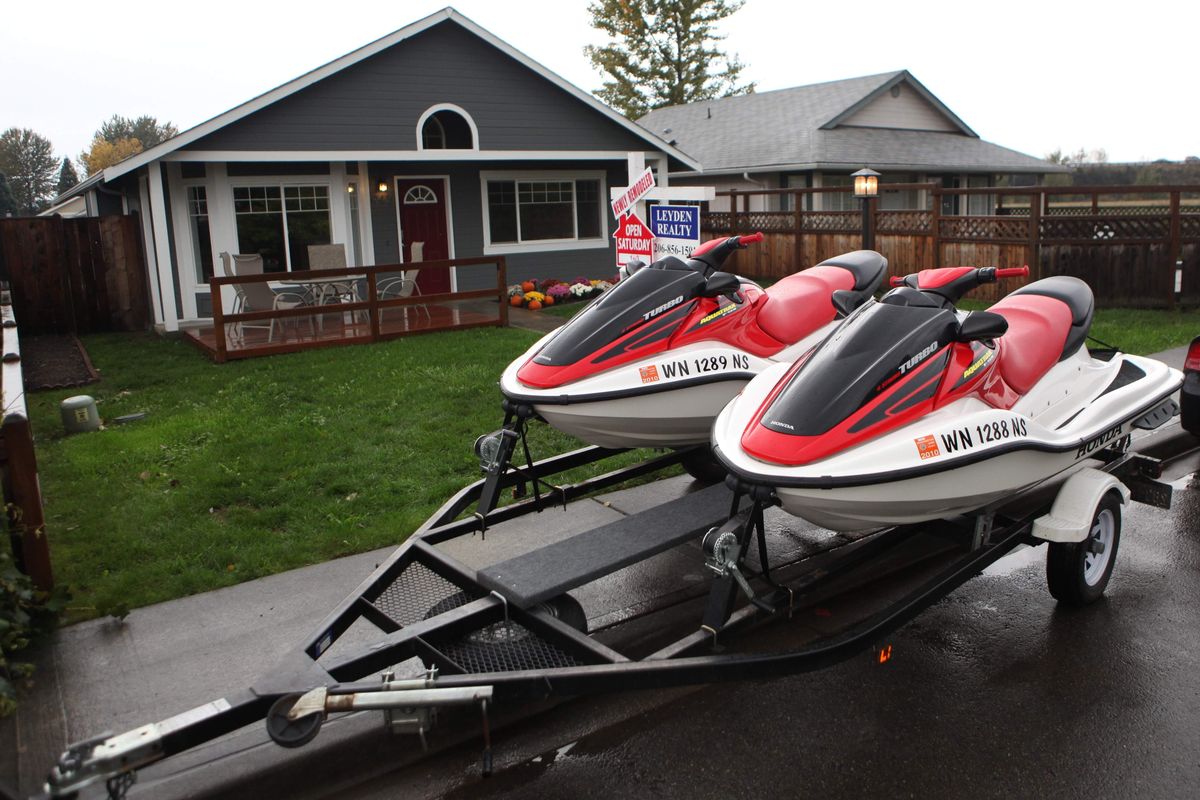 Left: Ryan Hopkins is  offering personal watercraft as “evacuation vehicles” as an incentive to buy his Kent, Wash., home. Seattle Times (Cliff DesPeaux Seattle Times)
