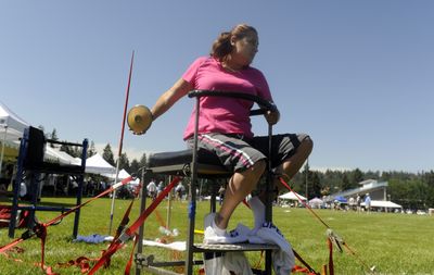 Seated in an anchored chair, Amy Riter competes in the discus.  (Jesse Tinsley / The Spokesman-Review)