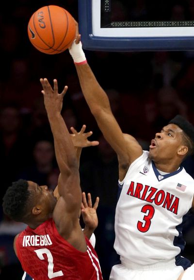 Arizona guard Justin Simon  blocks a shot by Washington State guard Ike Iroegbu during Saturday’s Pac-12 game. (Kelly Presnell / Arizona Daily Star)