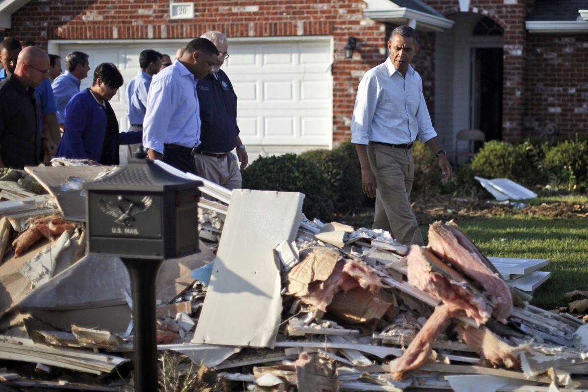President Barack Obama walks past debris on the sidewalks as he tours the Bridgewood neighborhood in LaPlace, La., in Saint John the Baptist Parish, with local officials to survey the ongoing response and recovery efforts to Hurricane Isaac, Monday, Sept. 3, 2012. (Pablo Monsivais / Associated Press)