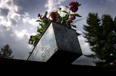 
A tin planter on a porch reflects afternoon light on its shiny surface. Planters offer an easy change to a porch by providing variety and easy mobility. 
 (Brian Plonka photos/ / The Spokesman-Review)