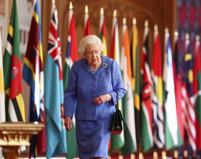 Britain's Queen Elizabeth II walks past Commonwealth flags in St George's Hall at Windsor Castle, England to mark Commonwealth Day in this image that was issued on Saturday March 6, 2021. The timing couldn’t be worse for the Queen's grandson Harry and his wife Meghan. The Duke and Duchess of Sussex will finally get the chance to tell the story behind their departure from royal duties directly to the public on Sunday, when their two-hour interview with Oprah Winfrey is broadcast.  (Steve Parsons)