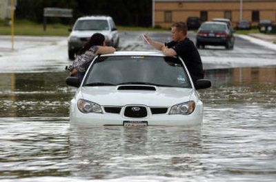 
A couple sit in the windows of their vehicle as floodwaters along Priest Drive wash over the road Friday in Killeen, Texas. 
 (Associated Press / The Spokesman-Review)