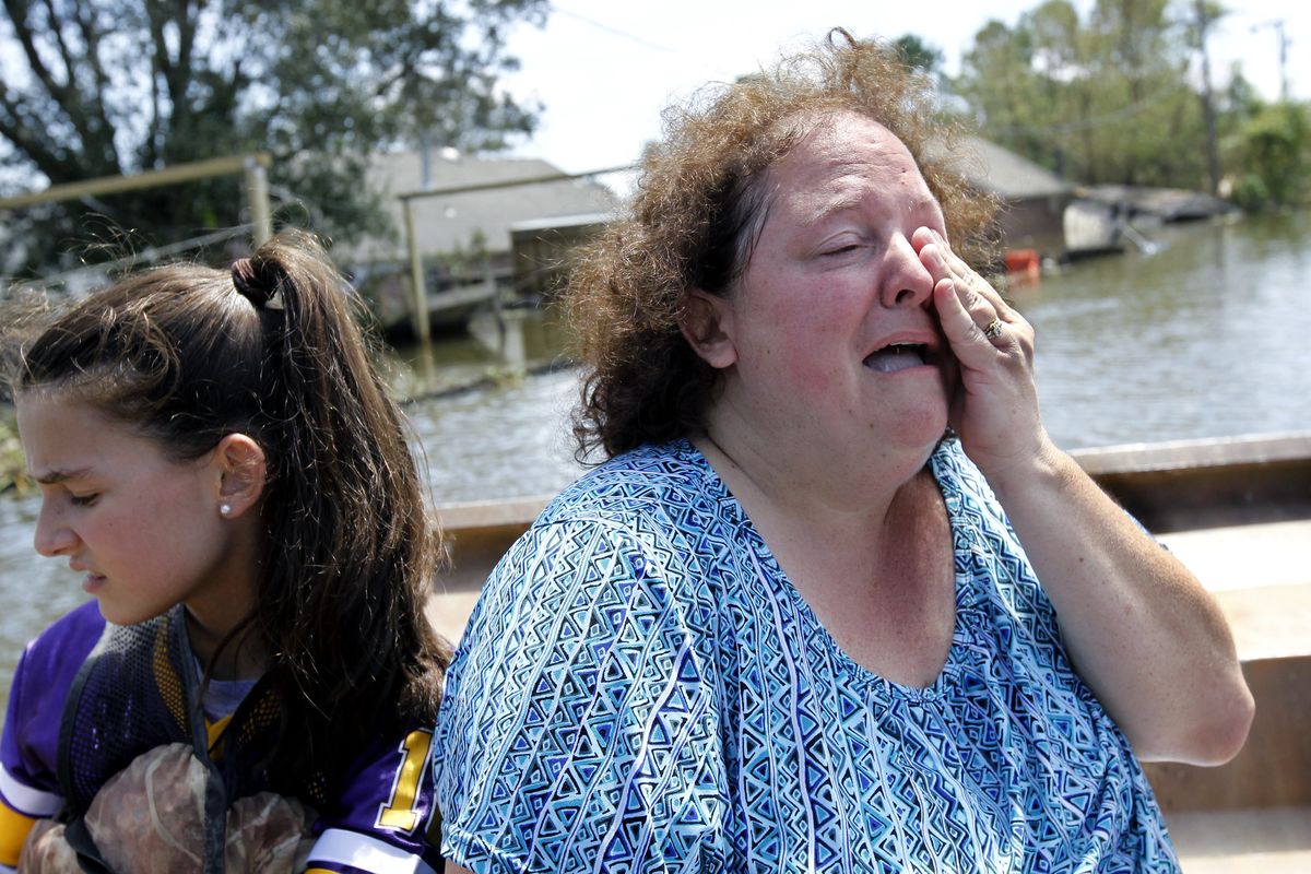 Angela Serpas cries as she sees her flooded home for the first time since Hurricane Isaac pushed a 10-foot storm surge into Braithwaite, La., Saturday, Sept. 1, 2012. At right is her daughter Lainy Serpas, 11.  While New Orleans streets were bustling again and workers were returning to offshore oil rigs, thousands of evacuees couldn