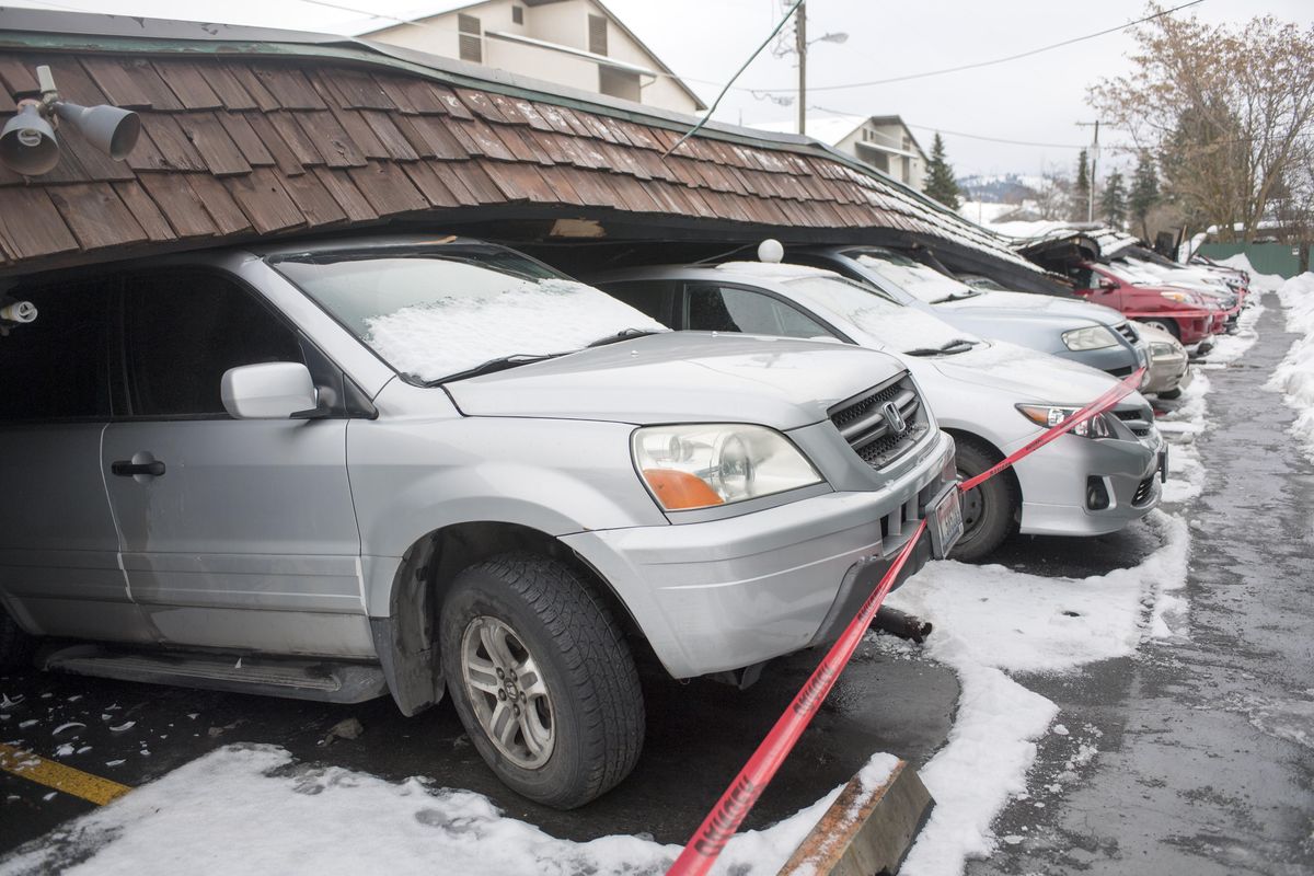 More than a dozen cars were damaged or destroyed when a long carport collapsed Sunday at the Edgewater Village condominiums at 2121 East Upriver Drive in Spokane, shown here Monday, Feb. 6, 2017. (Jesse Tinsley / The Spokesman-Review)