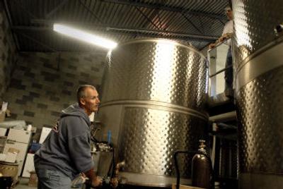 
Volunteer Steve Simisky prepares to open the valve to let juice pressed from chardonnay grapes enter a tank Thursday at Coeur d'Alene Cellars. 
 (Photos by JESSE TINSLEY / The Spokesman-Review)