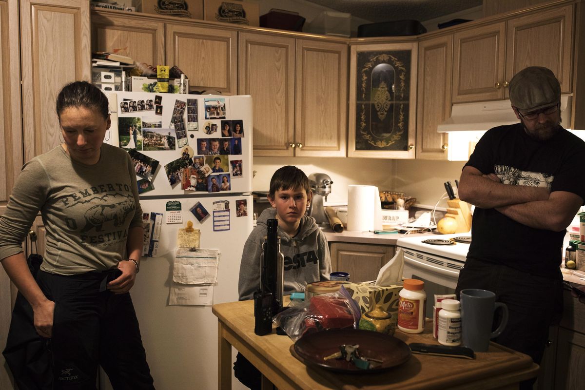 Brennan Caton, center, Misty Lawson and Courtney Caton, right, listen to the coast guard radio inside their home for updates on the tsunami warnings that shook Tofino, British Columbia, after the Alaskan earthquake on Tuesday, Jan. 23, 2018. A tsunami warning issued for coastal British Columbia was canceled Tuesday morning after some people living along parts of the province