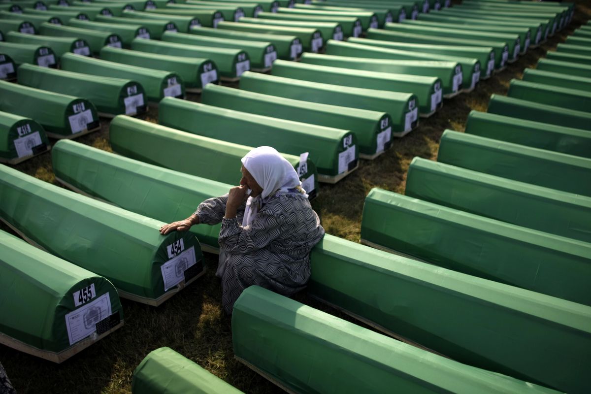 A Bosnian Muslim woman sits next to a coffin of her relative at the Potocari Memorial Center in Potocari, Bosnia-Herzegovina, on Sunday.  (Associated Press)