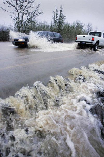 
Floodwaters flow over Territorial Road near Lorane, Ore., on Friday. Heavy rains and high winds lashed the state Friday, prompting flood warnings on rivers from the Portland area to the California border. 
 (Associated Press / The Spokesman-Review)