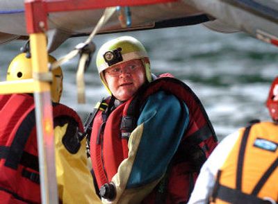 
Shawn Smith and other water rescue volunteers head out  to search for a man who was reported  to be clinging  to brush in the Spokane River near  downtown on Sunday.
 (Joe Barrentine / The Spokesman-Review)