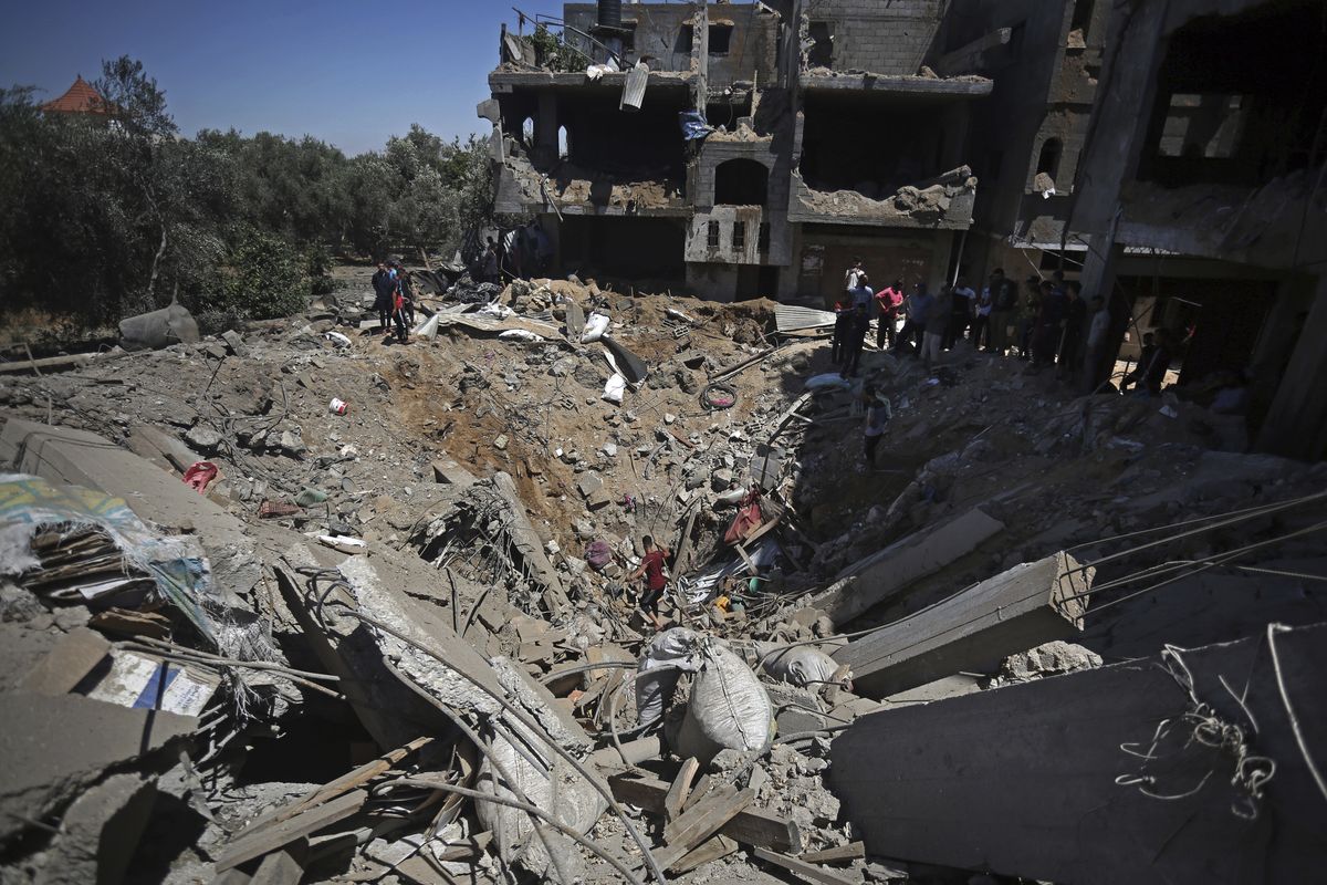 Palestinians inspect the damage of a destroyed house that was hit by an Israeli airstrike in town of Khan Younis, southern Gaza Strip, Wednesday, May 19, 2021.  (Yousef Masoud)