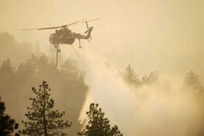 
A helicopter sprays water onto a burning wildfire near Green Valley, Calif. on Friday. Associated Press
 (File Associated Press / The Spokesman-Review)