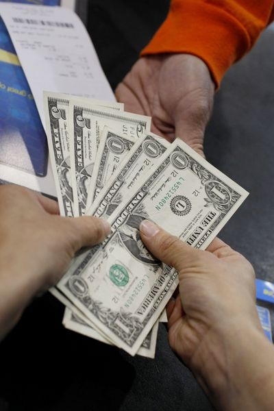 A Best Buy saleswoman, bottom, gives change to a customer at Best Buy in Mountain View, Calif. Consumer spending plunged in September.  (Associated Press / The Spokesman-Review)