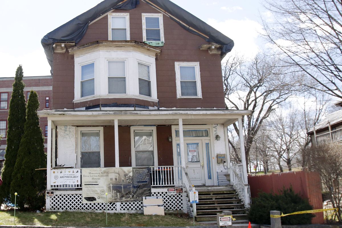 FILE - In this March 29, 2016, file photo, signs call attention to the house where slain African-American leader Malcolm X spent part of his childhood in the Roxbury neighborhood of Boston. According to the National Park Service the house was added to the National Register of Historic Places in February 2021. (Bill Sikes)