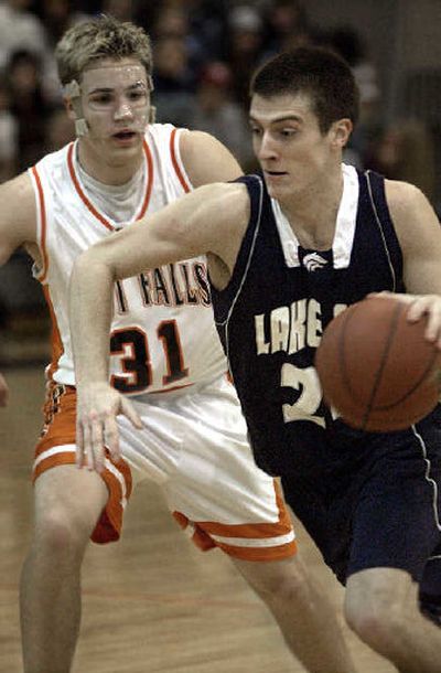 
Lake City's Brett Bemis drives by Post Falls defender Brandon Haas on Friday night at Post Falls High School.
 (Tom Davenport / The Spokesman-Review)