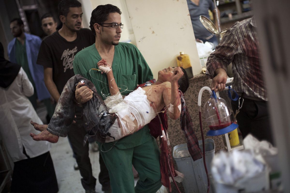 A doctor carries a severely wounded Syrian boy in the Dar El Shifa hospital, in Aleppo, Syria Thursday, Oct. 4, 2012 after the child was hit by Syrian Army shelling. The border violence between Turkey and Syria has added a dangerous new dimension to Syria
