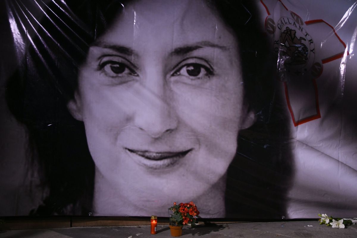 FILE - In this Tuesday, Oct. 16, 2018 file photo, flowers and a candle lie in front of a portrait of slain investigative journalist Daphne Caruana Galizia during a vigil outside the law courts in Valletta, Malta. An independent inquiry into the murder of investigative journalist Daphne Caruana Galizia released on Thursday, July 29, 2021 has found that the Maltese state “has to bear responsibility” for the assassination due the culture of impunity emanating from the highest levels of government. Caruana Galizia’s family had sought the inquiry into the Oct. 16, 2017 car bombing near the family home in Malta. The murder in the small EU country sent shockwaves felt not just in Malta, but throughout Europe.  (Jonathan Borg)