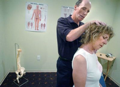 
Dr. Brian Flake works with Loni Reynolds in his Garland Avenue office Friday. 
 (Joe Barrentine / The Spokesman-Review)