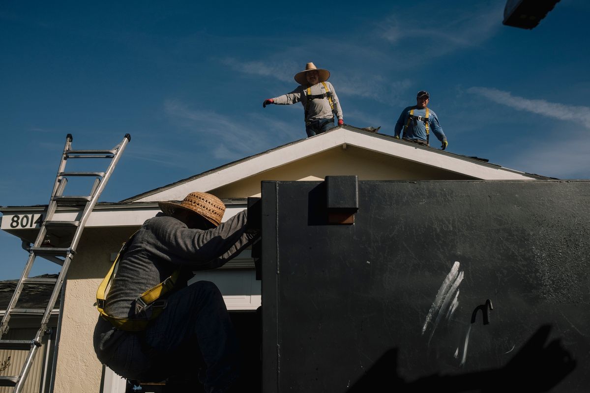 Crews work on a roof being repaired on Nov. 24 in San Diego. (MARK ABRAMSON)