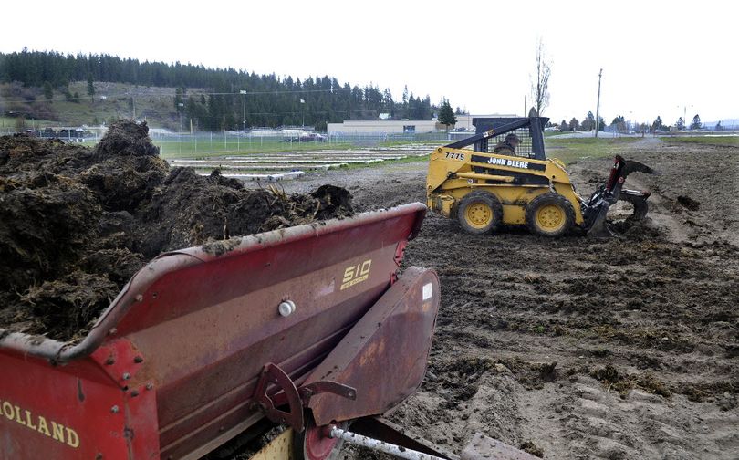 Eldon Jon of AC Starr Farms finishes spreading a load of cow manure donated by neighbor Carol Bear on the East Valley Schools Farm on Monday. The field is between East Valley High School and East Valley Middle School off Sullivan Road on Wellesley Avenue.  (J. Bart Rayniak)