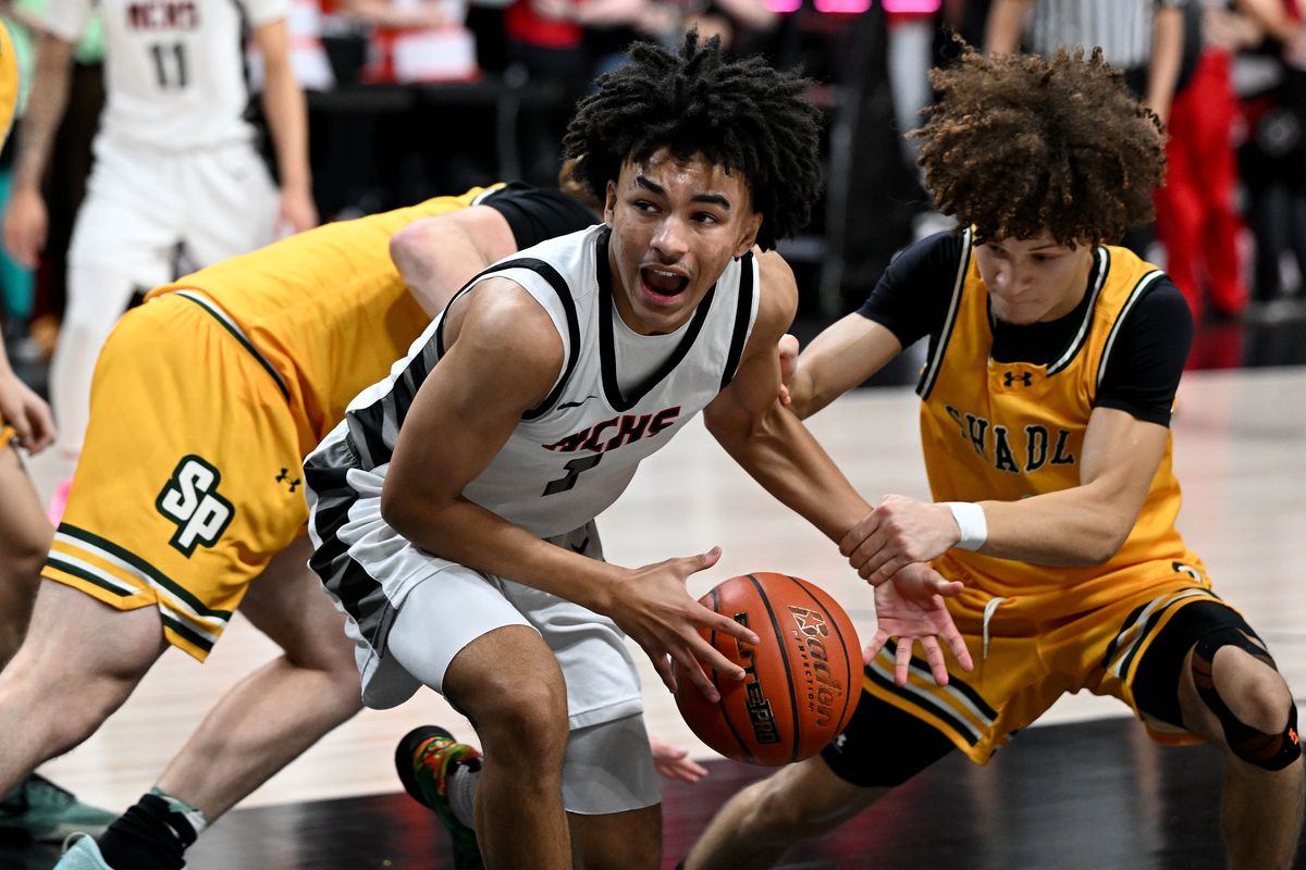 North Central guard Isaac Williams, center, tries to get past the defense of Shadle Park guard Elijah Williams during the Groovy Shoes spirit game Friday at the Arena. (Colin Mulvany/The Spokesman-Revi)