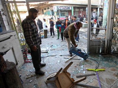 
Merchants clear debris from their shop near the site of a Saturday car-bomb attack in downtown Baghdad. Three bombs were detonated near a food market in a predominantly Shiite area, killing at least 51 people. 
 (Associated Press / The Spokesman-Review)