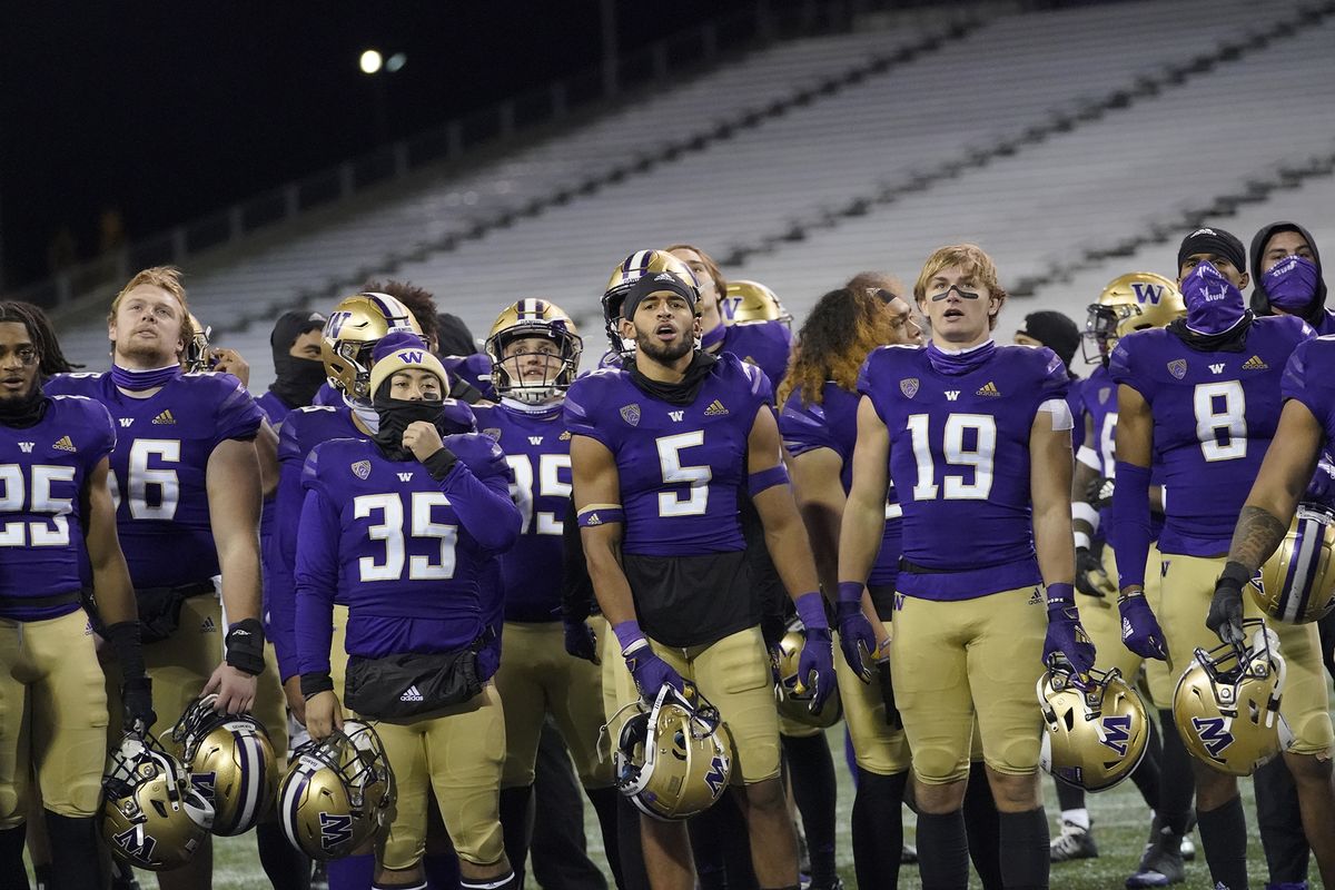 Washington players, including Christian Galvan (35), Alex Cook (5) and Sawyer Racanelli (19), stand on the field after the Huskies defeated Oregon State 27-21 in Pac-12 play Nov. 14 in Seattle.  (Associated Press)