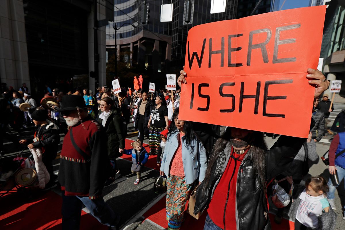 Dennis Willard, of Bellevue, holds up a protest sign as he marches in support of missing and murdered indigenous women during a rally to mark Indigenous Peoples’ Day on Oct. 14, 2019, in downtown Seattle.  (Ted S. Warren)