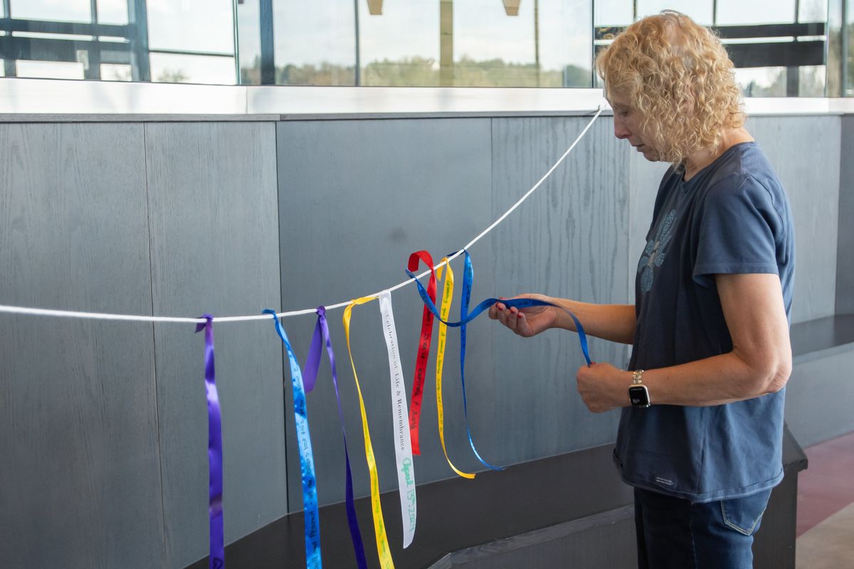 Laurie Moyer, of Spokane, looks at the ribbon she tied to the Remembrance Garland following the Celebration of Life &amp; Remembrance for Our Companion Animals ceremony on Saturday, April 13, 2024, on the Washington State University campus in Pullman. The ceremony, which is organized by Scott Campbell, the veterinary chaplain at Washington State University's College of Veterinary Medicine, is held several times a year. (WSU College of Veterinary Medicine/Ted S. Warren)  (WSU College of Veterinary Medicine/Ted S. Warren)