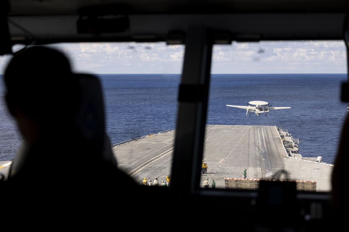 Crew members watch from the bridge as an E-2 Hawkeye is catapulted off the USS George Washington (CVN-73) off the coast of Florida on Sept. 14, 2023.    (Billy Schuerman/The Virginian-Pilot/TNS)