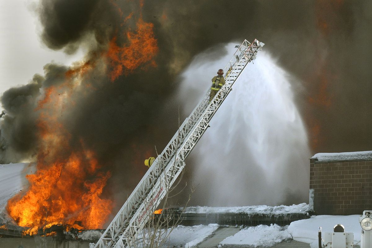 A Spokane, Wash. firefighter climbs up an aerial ladder to check the progress of a fire in the east central area Tuesday December 30, 2008.  The multiple alarm fire sent huge plumes of flame and smoke over the city and destroyed the business.  (Christopher Anderson / The Spokesman-Review)