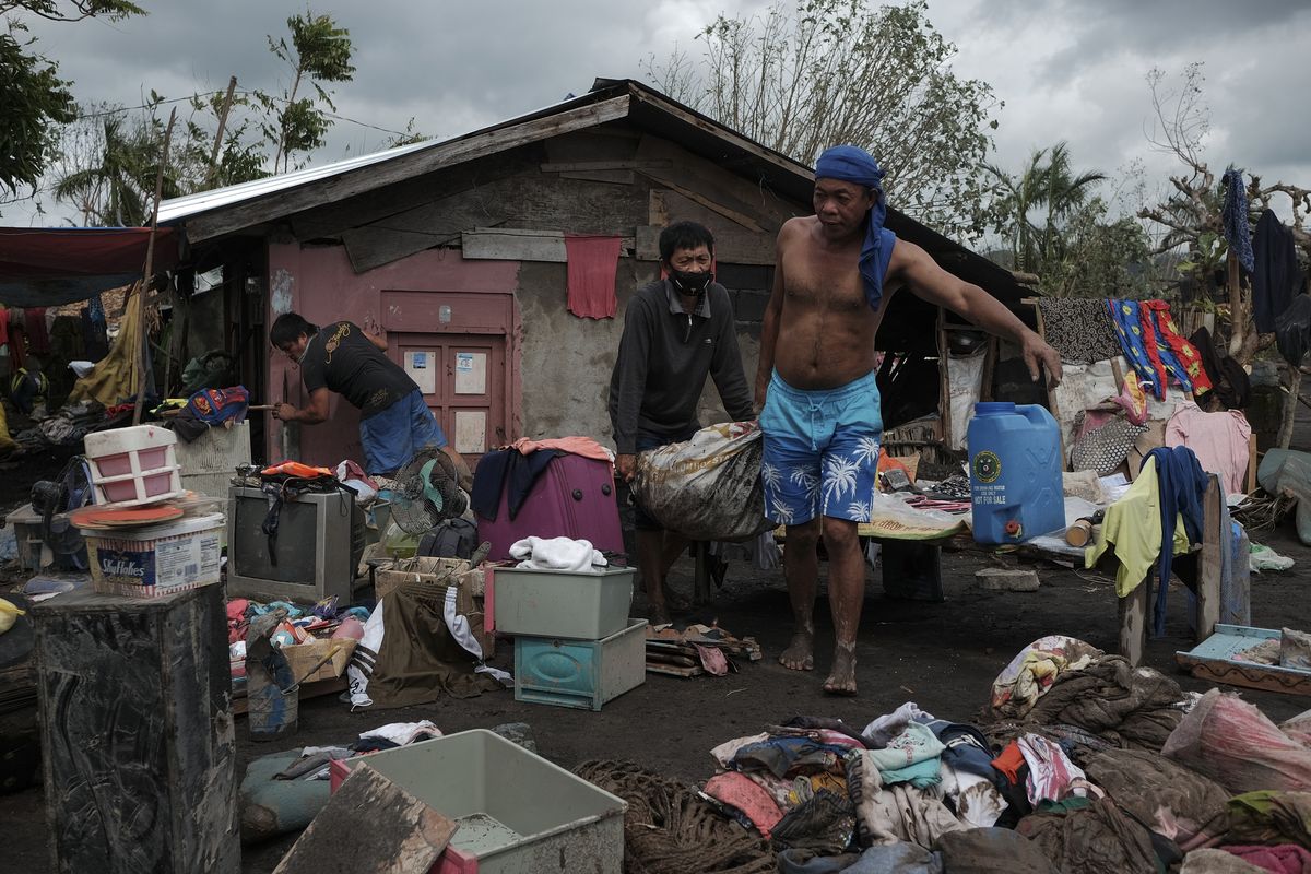 Residents try to save what’s left of their belongings after heavy rains from Typhoon Goni washed down boulders and mudflows from Mayon Volcano, engulfing about 150 houses in a single community Monday in the town of Guinobatan, Albay province, central Philippines. (John Michael Magdasoc)