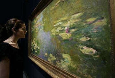 An auction house worker poses in front of Claude Monet's 